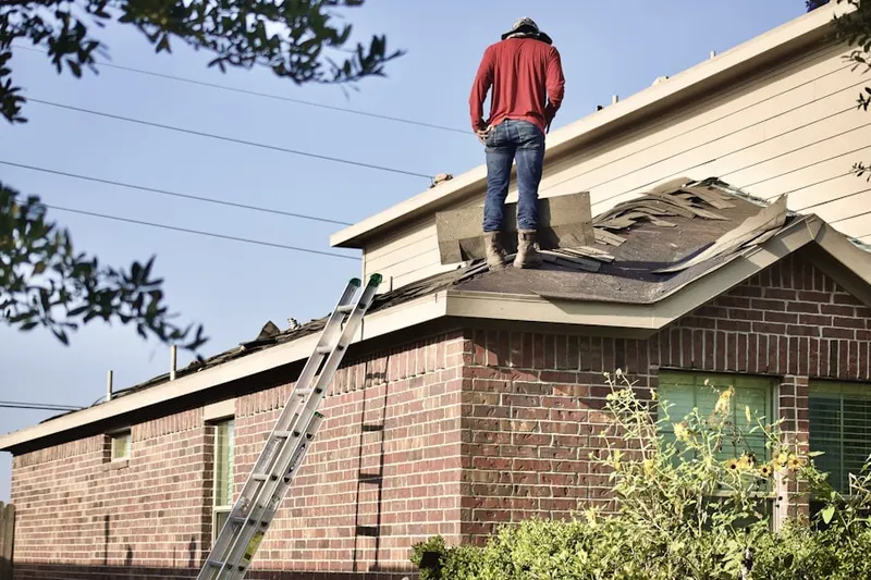 Professional roofer working on a residential roof in Grace